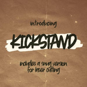 May include: Brown paper background with the word "KICKSTAND" in bold black letters, set against a white brushstroke. The text "introducing" and "includes a snug version for laser cutting" are also present.