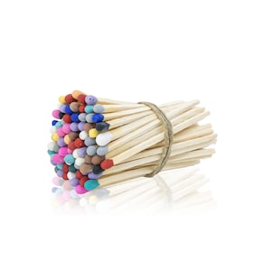 May include: A bundle of wooden matches with colorful painted heads. The matches are tied together with twine.