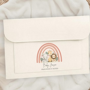 May include: A cream-coloured pregnancy notes folder with a flap closure. It features a watercolour illustration of a rainbow, elephant, giraffe, and lion. The text reads "Baby Jenson" and "Pregnancy Notes".