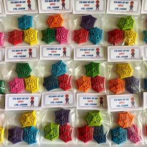 May include: Colorful spiderweb-shaped crayons in various colors, packaged in clear bags. Each bag includes a label with the text "YOU MADE MY DAY SUPER! LOVE, GRAHAM" and a Spider-Man graphic. A fun and creative craft supply.