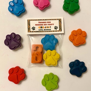 May include: A collection of colorful paw-shaped crayons and an orange number 3, packaged with a card that reads "Thanks for Making My Party GRR-IFIC! Love, Hannah." The crayons are in various colors, including blue, pink, green, orange, purple, yellow, and red.