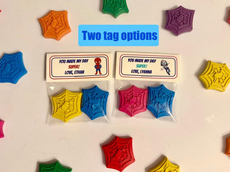 May include: Colorful Spider-Man themed party favors. The image shows various colors of spider web shaped wax crayons, with two tag options. The tags read "You made my day SUPER!" and include the names Ethan and Lyanna.