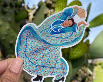 May include: A sticker featuring a woman in a blue dress with a floral pattern, dancing with a fan in her hand. The sticker is on a white background.
