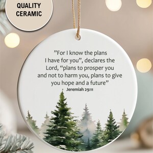 An aesthetic Christian Christmas ornament with bible verse from Jeremiah 29:11 "For I know the plans I have for you", featuring a watercolor pine trees design . Personalize it with name and date and it becomes a unique religious keepsake gift for a men and women. 

Our meticulously handprinted keepsake ornaments are crafted from premium quality ceramic using high quality ink. Will never fade. Scratch resistant. 100% satisfaction guarantee.