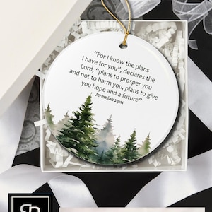 An aesthetic Christian Christmas ornament with bible verse from Jeremiah 29:11 "For I know the plans I have for you", featuring a watercolor pine trees design . Personalize it with name and date and it becomes a unique religious keepsake gift for a men and women. 

Our meticulously handprinted keepsake ornaments are crafted from premium quality ceramic using high quality ink. Will never fade. Scratch resistant. 100% satisfaction guarantee.