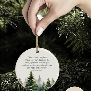 An aesthetic Christian Christmas ornament with bible verse from Jeremiah 29:11 "For I know the plans I have for you", featuring a watercolor pine trees design . Personalize it with name and date and it becomes a unique religious keepsake gift for a men and women. 

Our meticulously handprinted keepsake ornaments are crafted from premium quality ceramic using high quality ink. Will never fade. Scratch resistant. 100% satisfaction guarantee.