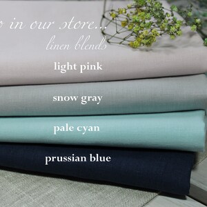 Może przedstawiać: Stosik czterech pr&oacute;bek tkaniny w r&oacute;żnych kolorach: jasnor&oacute;żowy, szaro-biały, jasnoniebieski i błękit pruski. Tekst "Also in our store... linen blends" jest widoczny w g&oacute;rnej części obrazu.