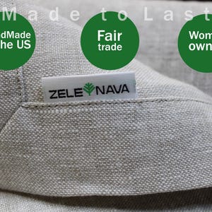May include: Close-up of a light gray linen fabric with the text "Made to Last". The image includes green circles with the text "Handmade in the US", "Fair trade", and "Women owned". A white tag reads "ZELE NAVA".