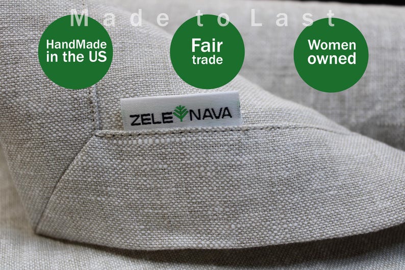 May include: Close-up of a light gray linen fabric with the text "Made to Last". The image includes green circles with the text "Handmade in the US", "Fair trade", and "Women owned". A white tag reads "ZELE NAVA".