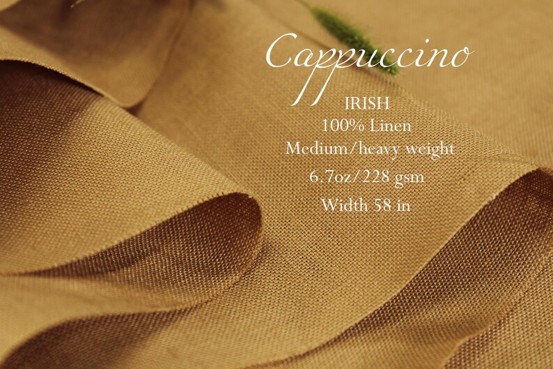 K&ouml;nnte beinhalten: Nahaufnahme eines gefalteten Stoffes in Cappuccino-Farbe. Der Text auf dem Stoff lautet "Cappuccino", "IRISH", "100% Linen", "Medium/heavy weight", "6.7oz/228 gsm" und "Breite 147 cm".