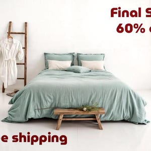 May include: A bed with a sage green duvet cover, two sage green pillowcases, and two white rectangular pillows. A wooden ladder stands to the left with a white robe hanging on it. A small wooden bench sits at the foot of the bed. Text reads Final Sale 60% off.