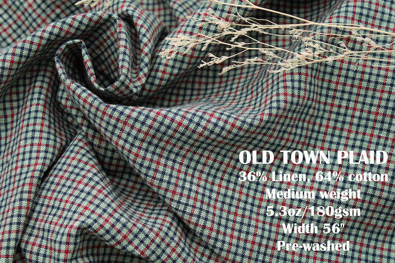 May include: A fabric with a plaid pattern in red, navy blue, and light green. Text on the fabric reads: OLD TOWN PLAID, 36% Linen, 64% cotton, Medium weight, 5.3oz/180gsm, Width 56", Pre-washed. A dried plant sprig rests on the folded textile surface.