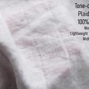 May include: White linen fabric featuring a tone-on-tone plaid pattern. The textile is washed, lightweight at 125gsm or 3.7 oz, and has a width of 58 inches. The text on the image reads: Tone-on-Tone Plaid White 100% Linen Washed Lightweight 125gsm/3.7 oz Width 58".