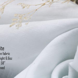 K&ouml;nnte beinhalten: Wei&szlig;er Stoff aus 100 % Leinen, mittelschwer, 6,6 oz, 147 cm breit, weich. Der Stoff ist drapiert, mit weichen Falten und einem strukturierten Aussehen. Das Bild enth&auml;lt den Text "White", "100% linen fabric", "Medium-weight 6.6oz", "Width 58"" und "Softened".