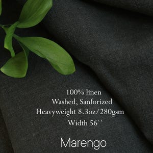 Pu&ograve; includere: Un tessuto in 100% lino lavato e sanforizzato di colore grigio scuro Marengo. Il tessuto &egrave; pesante, 280 g/m&sup2;, con una larghezza di 56 pollici. Il materiale presenta una trama visibile ed &egrave; mostrato con un piccolo rametto di foglie verdi.