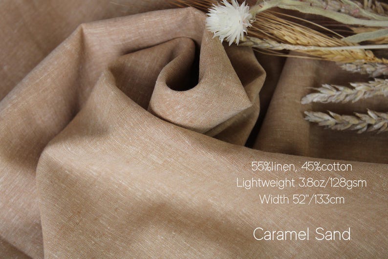 K&ouml;nnte beinhalten: Nahaufnahme eines karamellfarbenen Stoffes, 55 % Leinen und 45 % Baumwolle. Das leichte Material ist 133 cm breit. Der Text auf dem Bild lautet "Caramel Sand".