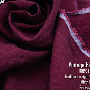 May include: A piece of deep burgundy linen fabric with a visible weave and a frayed edge. Text on the fabric reads: Vintage Burgundy, 100% Linen, Medium-weight 182gsm/5.4oz, Width 57", Prewashed. A small section of white lace is visible in the corner.