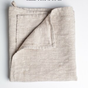 May include: A folded beige linen kitchen towel with the text "100% European linen SIZE 16.5 x 30 in" and the Oeko-Tex Standard 100 logo.