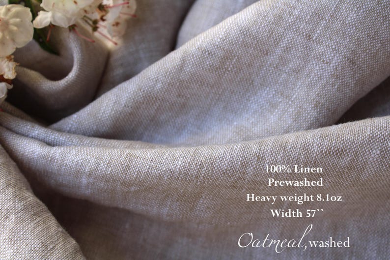 K&ouml;nnte beinhalten: Nahaufnahme eines gefalteten, hellbeigen Leinenstoffs. Der Stoff ist vorgewaschen und hat ein schweres Gewicht von 229 Gramm. Die Breite betr&auml;gt 145 cm. Der Text auf dem Stoff lautet "100% Linen", "Prewashed", "Heavy weight 8.1oz", "Width 57"" und "Oatmeal, washed".