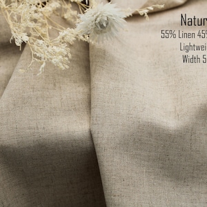 May include: A piece of natural-colored fabric with a visible weave, composed of 55% linen and 45% cotton. The material is lightweight with a width of 58 inches. Dried white flowers are placed on top of the folded, textured textile.