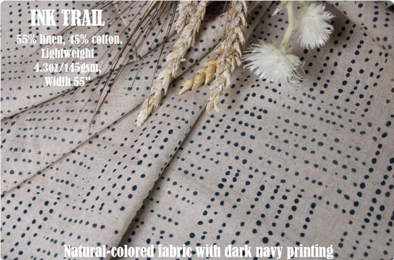May include: A natural-colored fabric featuring a dark navy blue dotted pattern. The text on the fabric reads: INK TRAIL, 55% linen, 45% cotton, Lightweight, 4.3oz/145gsm, Width 55". The material is draped and includes decorative dried wheat stalks.