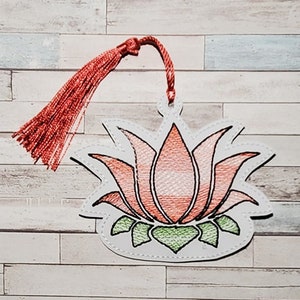 Peut inclure: Un marque-page blanc avec un motif de fleur de lotus brodé en rose et orange et un pompon rouge.