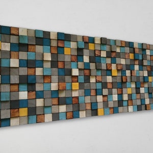 May include: A wall art piece made of wooden blocks in various shades of blue, brown, grey, and yellow. The blocks are arranged in a staggered pattern, creating a modern and abstract design.