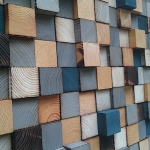 May include: A wall art piece made of wooden blocks in various shades of brown, gray, and blue. The blocks are arranged in a staggered pattern, creating a textured and modern look.