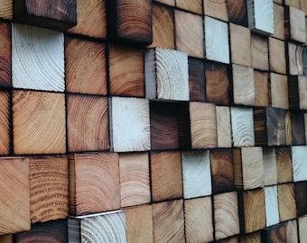 May include: A wall covered in a variety of wood squares, some are stained a dark brown, some are a light brown, and some are white.