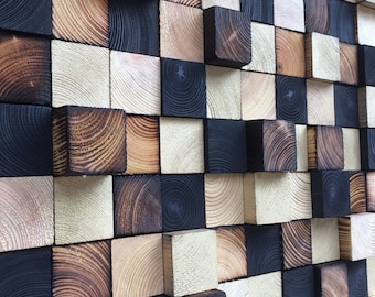May include: A wall art piece made of wooden blocks in various shades of brown, black, and white. The blocks are arranged in a staggered pattern, creating a textured and visually interesting surface.
