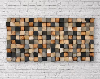 May include: A rectangular wall art piece composed of numerous small, square wooden blocks arranged in a grid. The blocks feature varying natural wood tones, including light tan, medium brown, dark charcoal, and gray, with visible wood grain textures.