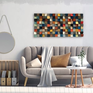 Peut inclure: Un canapé gris avec une couverture blanche et un coussin marron dans un salon. Un miroir rond est accroché au mur au-dessus d'une caisse en bois avec des dossiers. Une œuvre d'art murale en bois géométrique colorée est accrochée au-dessus du canapé.