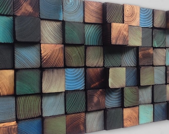 May include: A wall art piece made of wood blocks in various shades of blue, green, and brown. The blocks are arranged in a random pattern, creating a unique and modern design.
