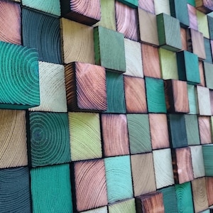 Puede incluir: Una obra de arte mural compuesta por bloques de madera en tonos verdes, marrones y beige. Los bloques están dispuestos en un patrón de mosaico, mostrando la veta y textura natural de la madera. La paleta de colores crea una estética natural y terrosa.