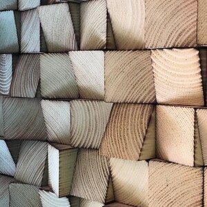 以下が含まれることがあります： 木製のブロックでできた壁で、ブロックは交互に配置されています。ブロックは青と茶色の色合いで塗られており、グラデーション効果を生み出しています。