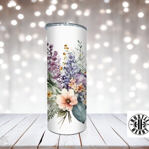 May include: White stainless steel tumbler with a floral design featuring purple, pink, and green watercolor flowers. The tumbler has a black lid and a black logo that says "Hustle Heart" with a barbell symbol.