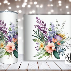 May include: A white tumbler with a watercolor floral design featuring purple, blue, yellow, and pink flowers. The tumbler has a white background and the floral design is centered on the tumbler.