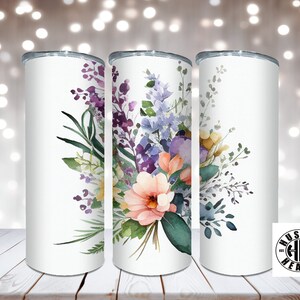 May include: Three white stainless steel tumblers with a floral design. The design features watercolor flowers in shades of pink, purple, blue, and yellow. The flowers are arranged in a bouquet with green leaves.