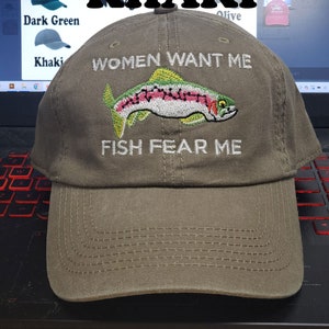May include: Khaki baseball cap with an embroidered trout and the text "Women Want Me Fish Fear Me".