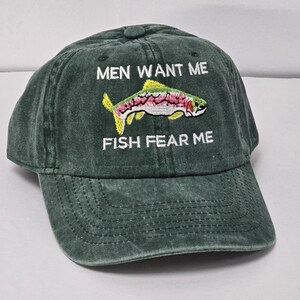 May include: A green baseball cap with the text "Men Want Me Fish Fear Me" and an embroidered image of a trout.