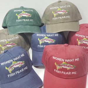 May include: Six different colored baseball caps with a rainbow trout embroidered on the front. The text "Women Want Me Fish Fear Me" is embroidered on each cap.
