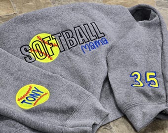 May include: Gray sweatshirt with the words "Softball Mama" and a yellow softball graphic on the front. The left sleeve has a yellow softball graphic with the word "Tony" inside. The right sleeve has the number "35" in blue and yellow.