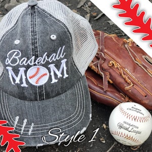 May include: A grey and white baseball cap with the text "Baseball MOM" embroidered on the front. The cap has a mesh back and a distressed look. A baseball glove and a baseball are also in the image.