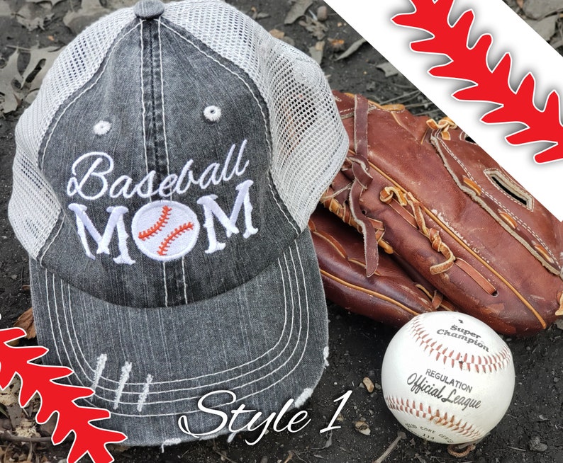 May include: A grey and white baseball cap with the text "Baseball MOM" embroidered on the front. The cap has a mesh back and a distressed look. A baseball glove and a baseball are also in the image.