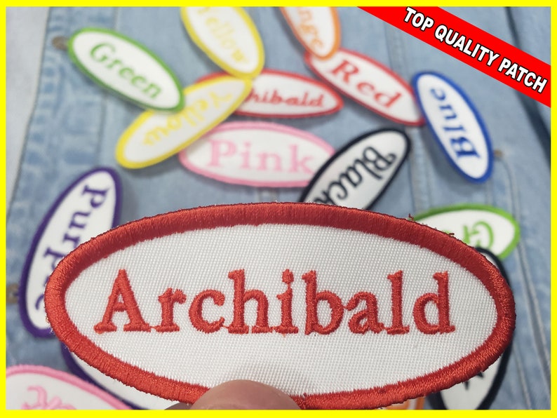 May include: Oval-shaped embroidered patches with various colors and names. One patch reads "Archibald" in red thread. Other patches display colors like green, yellow, and pink. The patches are on a denim background, with a "Top Quality Patch" banner.