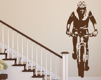 May include: A brown silhouette of a person riding a bicycle on a white wall. The person is wearing a helmet and is in mid-ride. The bicycle has a front suspension and a single gear.