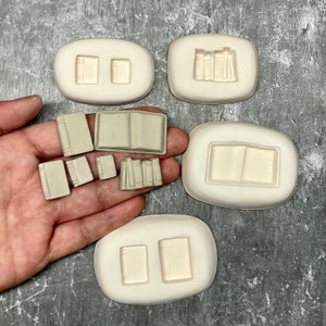 Può includere: Un set di stampi in silicone per realizzare libri in miniatura. Gli stampi sono di varie forme e dimensioni, tra cui una pila di libri, un libro singolo e un libro aperto. Gli stampi sono realizzati in silicone flessibile e sono facili da usare.