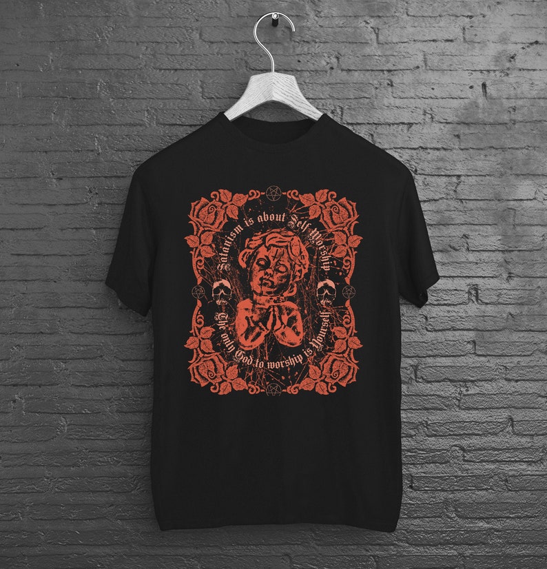 May include: Black t-shirt with a red graphic design featuring a cherub-like figure with the text "Satanism is about Self Worship. The only God to worship is yourself."