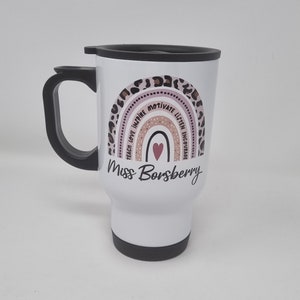 May include: White travel mug with a pink and brown rainbow design. The rainbow has the words "Teach Love Inspire Motivate Listen Encourage" written on it. The mug also has a pink heart and the text "Miss Borsberry".