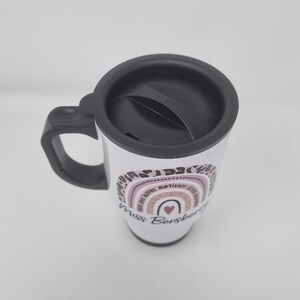 May include: White travel mug with a black lid and handle. The mug has a rainbow design with the words "Be Kind, Be Brave, Be Motivated, Be You" and "Miss Borsberg" printed on it.